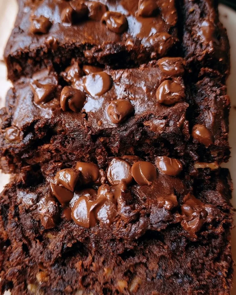 A slice of double chocolate banana bread topped with chocolate chips.